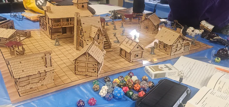 Painted miniatures and laser-cut terrain built at the studio