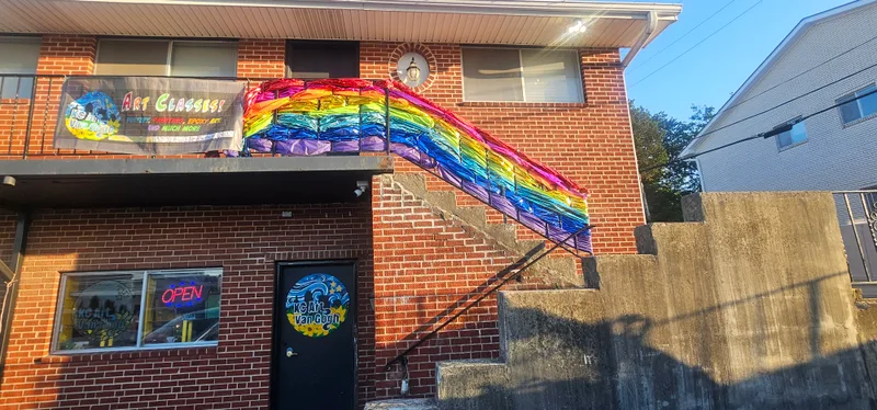 The studio exterior, with a rainbow mural painted on the brick